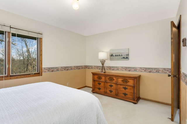 bedroom featuring light colored carpet and baseboards