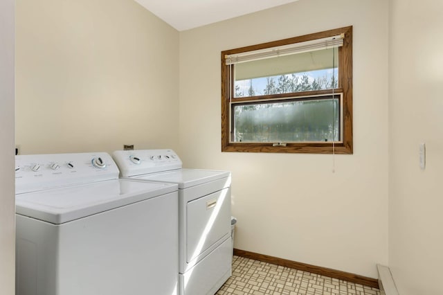 clothes washing area with washing machine and dryer and baseboards