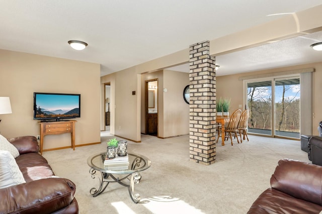 living room featuring ornate columns, carpet, and baseboards