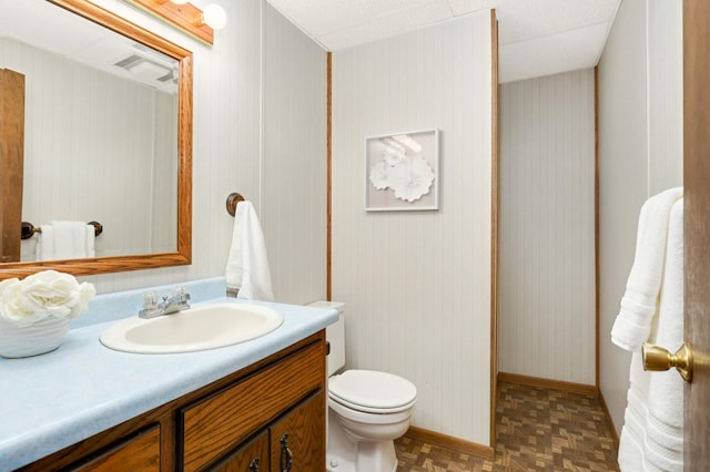 bathroom featuring vanity, toilet, and baseboards