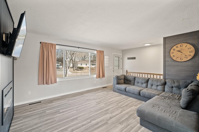 2510 152nd Ln NE, Ham Lake, MN 55304 - living area with a textured ceiling, wood finished floors, visible vents, and baseboards