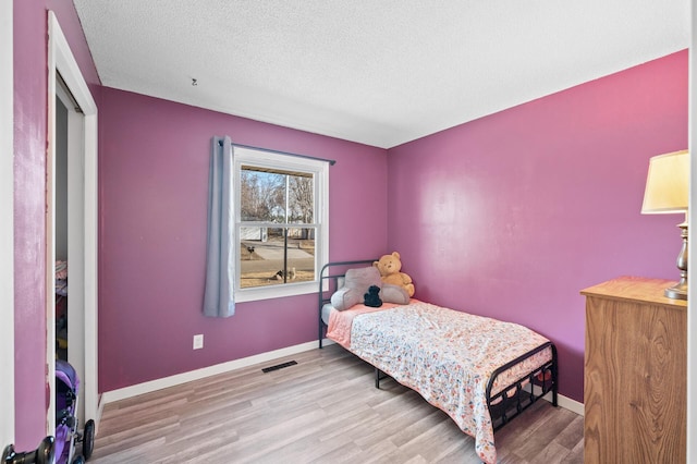2510 152nd Ln NE, Ham Lake, MN 55304 - bedroom featuring visible vents, a textured ceiling, baseboards, and wood finished floors