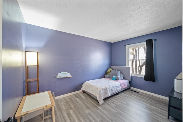 2510 152nd Ln NE, Ham Lake, MN 55304 - bedroom featuring visible vents, wood finished floors, baseboards, and a textured ceiling