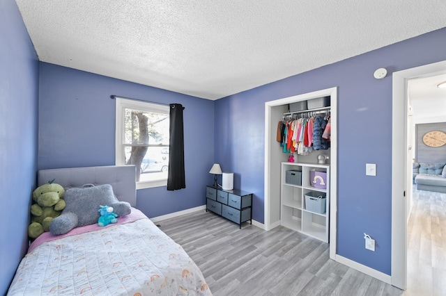 2510 152nd Ln NE, Ham Lake, MN 55304 - bedroom featuring baseboards, a closet, a textured ceiling, and light wood-style floors