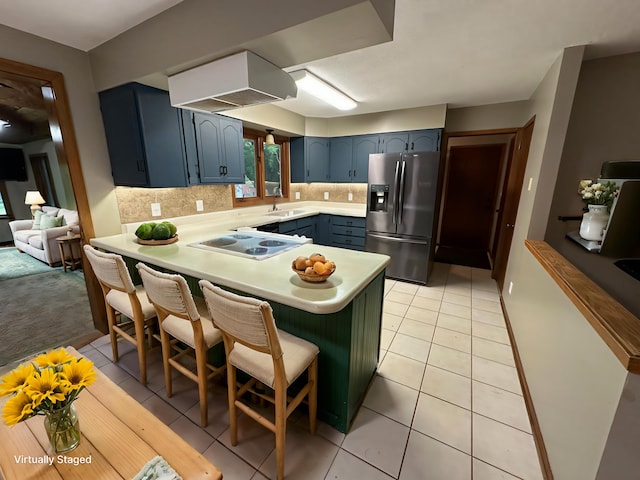 6480 Long Lake Rd, Willmar, MN 56201 - kitchen with stainless steel fridge with ice dispenser, cooktop, a peninsula, light countertops, and a kitchen bar