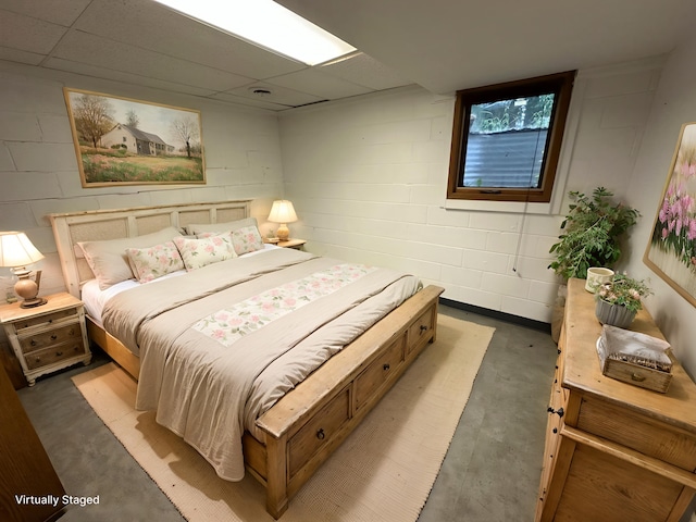 6480 Long Lake Rd, Willmar, MN 56201 - bedroom featuring concrete floors, concrete block wall, and a paneled ceiling