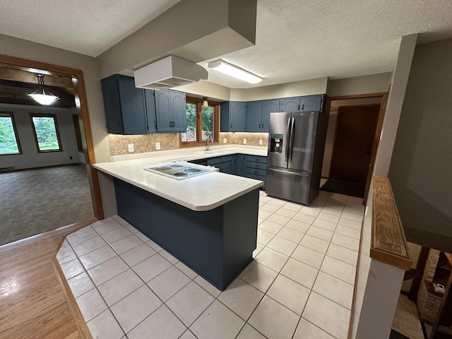 6480 Long Lake Rd, Willmar, MN 56201 - kitchen featuring stainless steel refrigerator with ice dispenser, a peninsula, electric cooktop, light countertops, and a textured ceiling