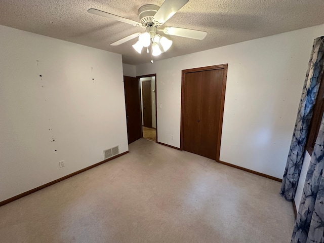 6480 Long Lake Rd, Willmar, MN 56201 - unfurnished bedroom with a textured ceiling, light colored carpet, a closet, and ceiling fan