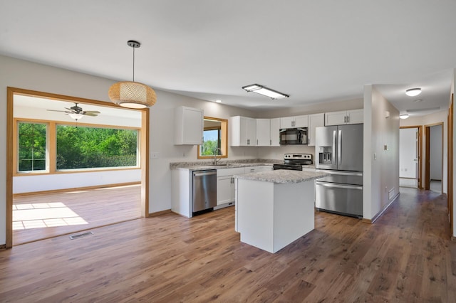 33373 Lakes Trl, Chisago Lake Twp, MN 55045 - kitchen with appliances with stainless steel finishes, a sink, white cabinetry, wood finished floors, and baseboards