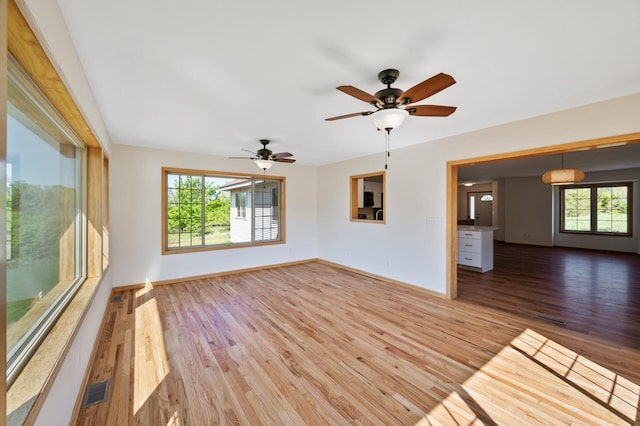 33373 Lakes Trl, Chisago Lake Twp, MN 55045 - unfurnished living room featuring plenty of natural light, wood finished floors, baseboards, and ceiling fan