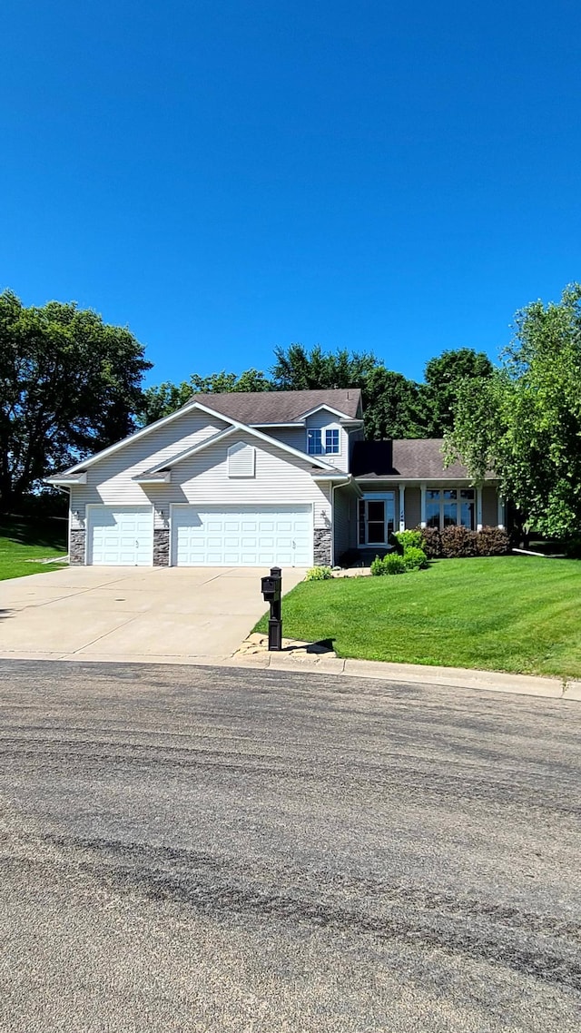 1404 19th Ave NW, Faribault, MN 55021 - view of front of house with a garage, driveway, stone siding, and a front yard