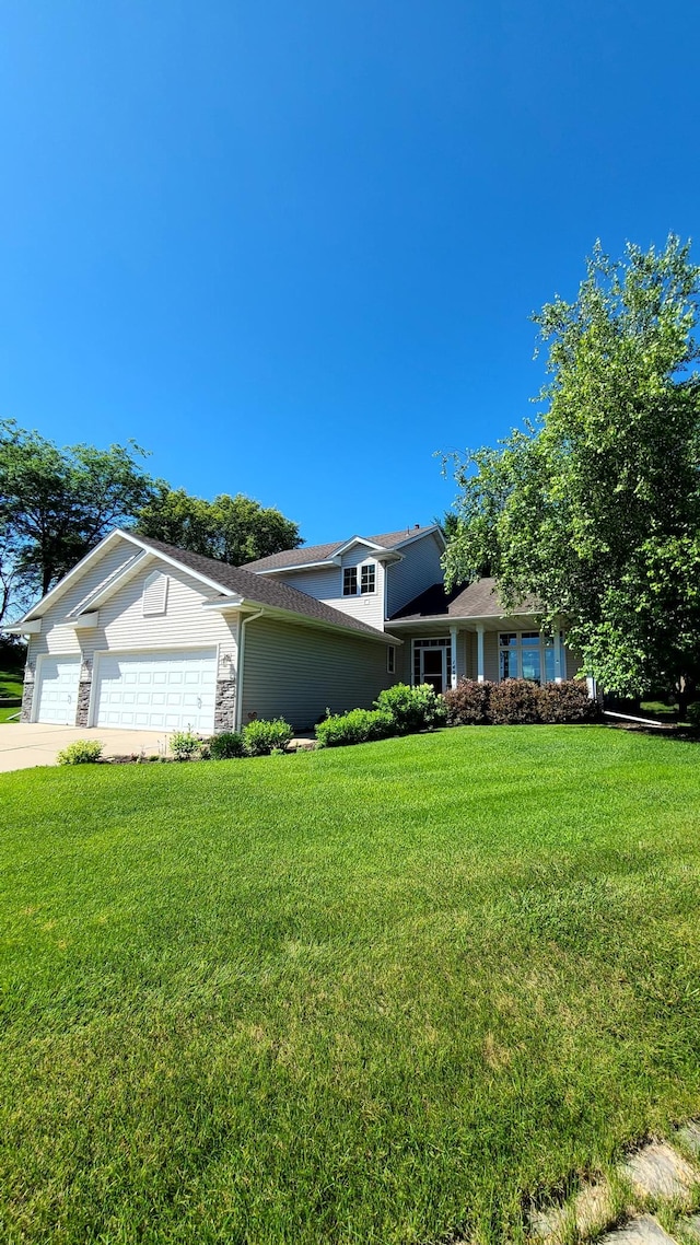 1404 19th Ave NW, Faribault, MN 55021 - split level home featuring an attached garage, a front lawn, driveway, and stone siding