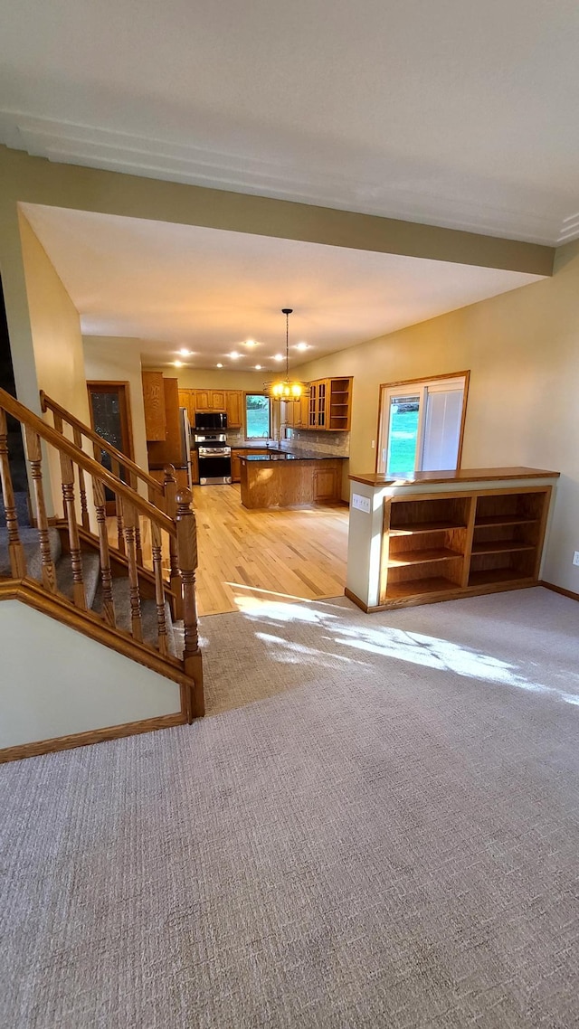 1404 19th Ave NW, Faribault, MN 55021 - living room featuring light carpet, stairway, and a chandelier
