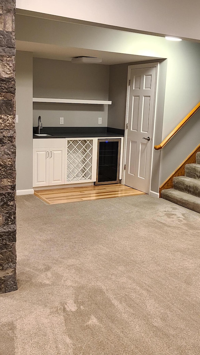 1404 19th Ave NW, Faribault, MN 55021 - unfurnished living room featuring carpet floors, bar, stairway, and beverage cooler