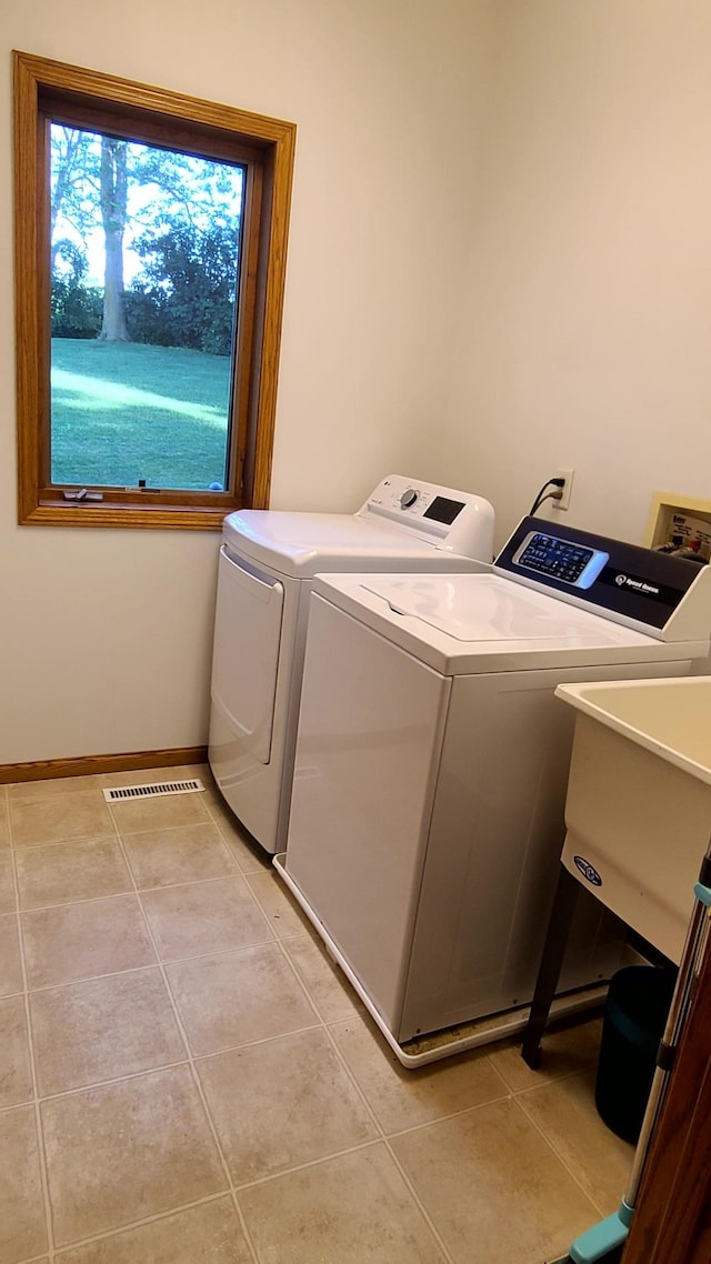 1404 19th Ave NW, Faribault, MN 55021 - laundry room featuring washing machine and clothes dryer and light tile patterned floors