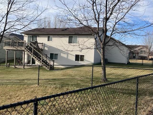 4846 Lionhart Dr NW, Rochester, MN 55901 - rear view of property with a deck, stairway, a fenced backyard, and a lawn