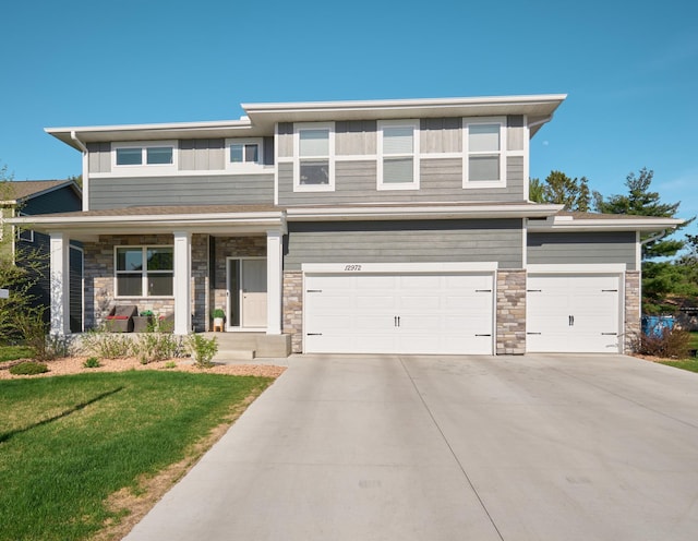 12972 Bauer Dr N, Champlin, MN 55316 - view of front of house with concrete driveway, stone siding, a garage, and a front yard