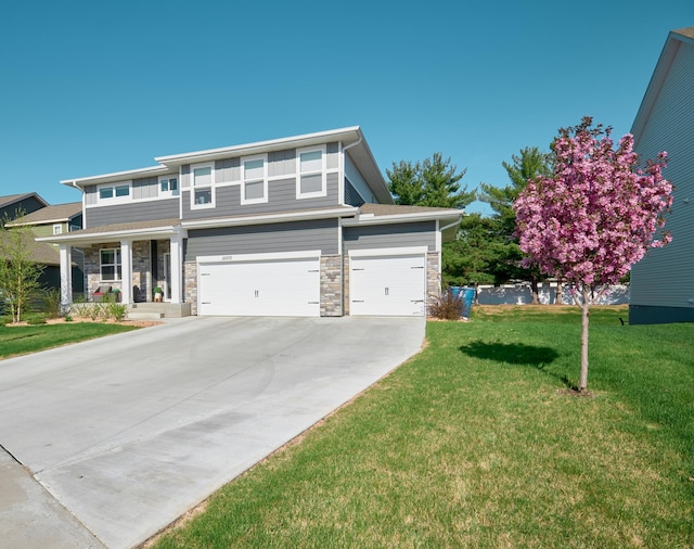 12972 Bauer Dr N, Champlin, MN 55316 - view of front of home with a front yard, driveway, stone siding, a porch, and an attached garage