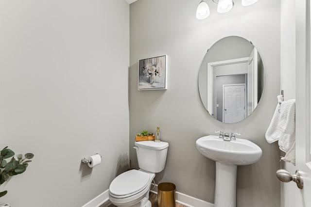 12972 Bauer Dr N, Champlin, MN 55316 - half bathroom featuring toilet, baseboards, wood finished floors, and a sink