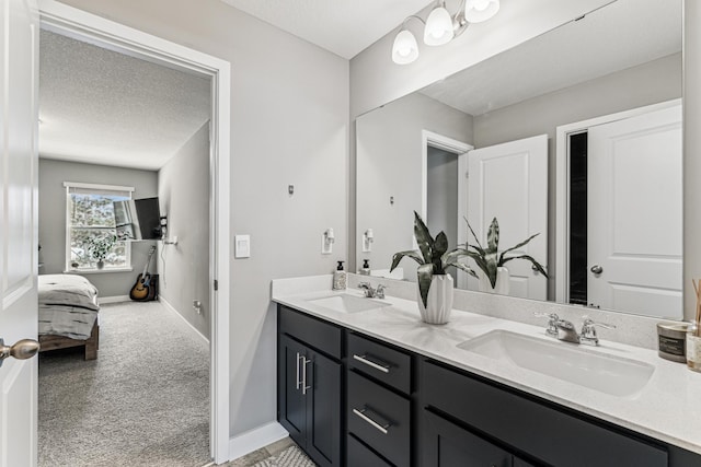 12972 Bauer Dr N, Champlin, MN 55316 - ensuite bathroom with baseboards, double vanity, and a textured ceiling