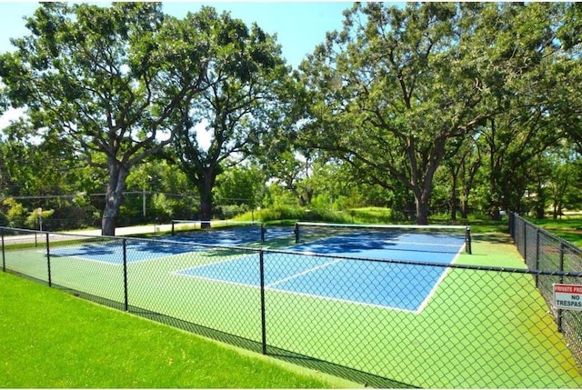 12972 Bauer Dr N, Champlin, MN 55316 - view of tennis court with fence and view of scattered trees