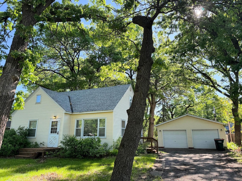 9055 Tyler St NE, Blaine, MN 55434 - view of front of property with a shingled roof, a garage, an outdoor structure, and a deck