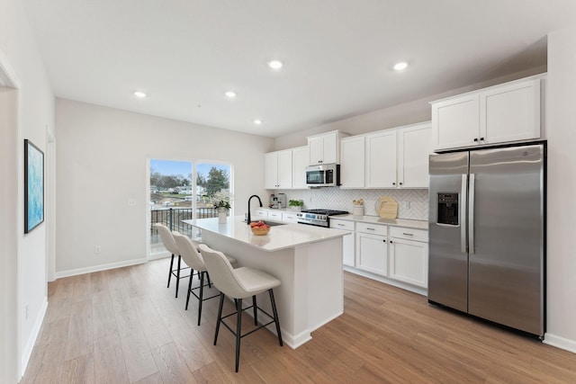 1537 Traverse Ln W, Saint Paul, MN 55118 - kitchen with appliances with stainless steel finishes, a sink, an island with sink, light wood-type flooring, and a breakfast bar area