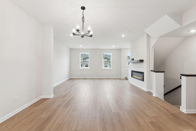 1537 Traverse Ln W, Saint Paul, MN 55118 - unfurnished living room with light wood-style floors, a chandelier, a glass covered fireplace, recessed lighting, and baseboards