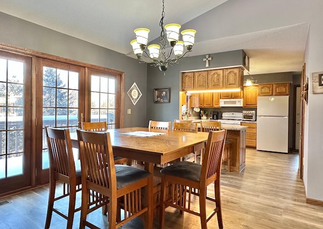 dining area with a notable chandelier, light wood-style flooring, and visible vents