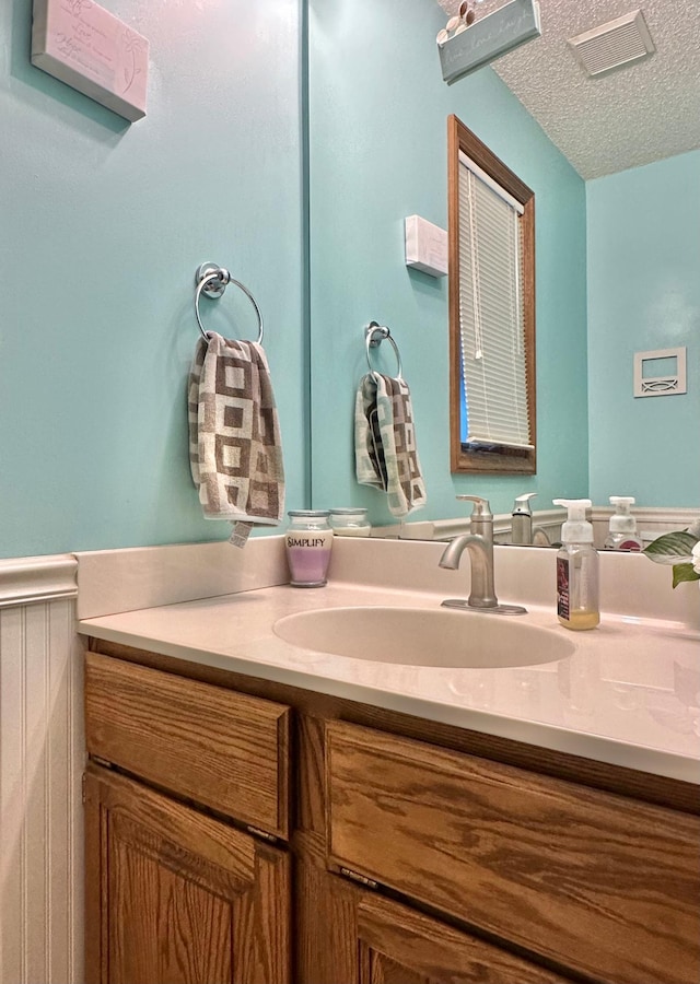 bathroom featuring vanity, a textured ceiling, and visible vents