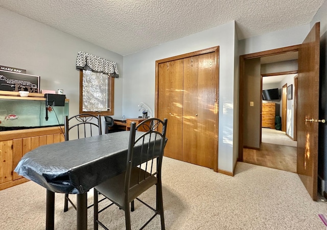 dining area featuring carpet and a textured ceiling