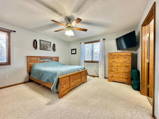 bedroom featuring carpet floors, a textured ceiling, baseboards, and ceiling fan