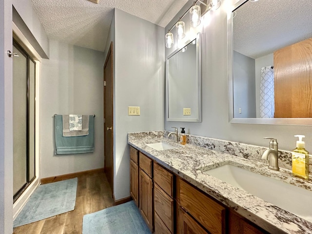 bathroom with a sink, a textured ceiling, and wood finished floors