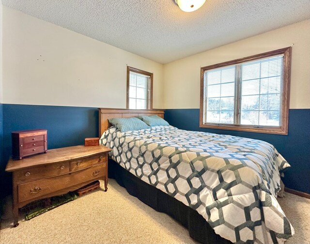 bedroom featuring a textured ceiling and light carpet
