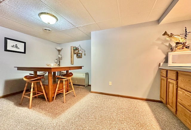 dining area featuring baseboards, visible vents, light carpet, and a paneled ceiling