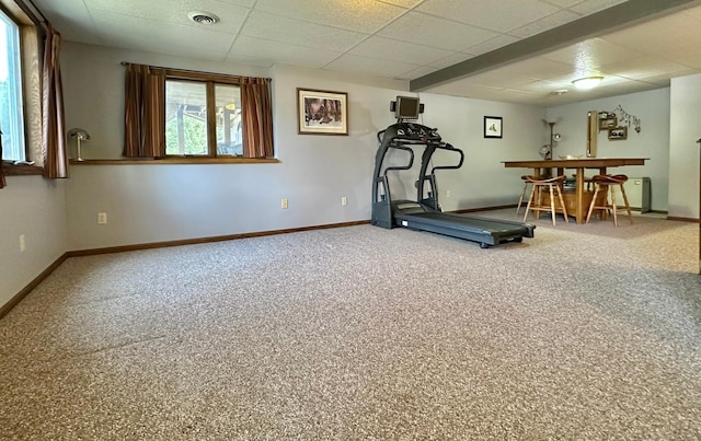 workout room with baseboards, carpet, a paneled ceiling, and a bar