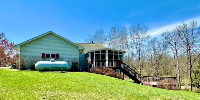 back of house featuring a yard, stairway, and a sunroom