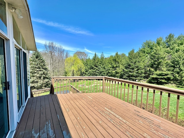 wooden deck with a yard and a wooded view