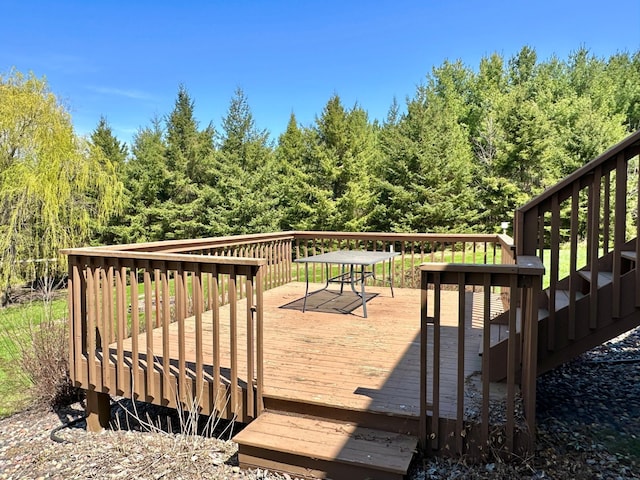 wooden terrace featuring a view of trees