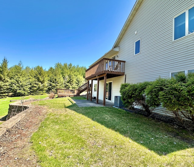 view of yard with a deck, central AC, and stairs