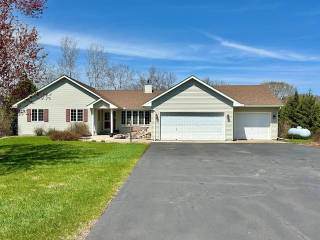ranch-style home with a garage, a front lawn, aphalt driveway, roof with shingles, and a chimney