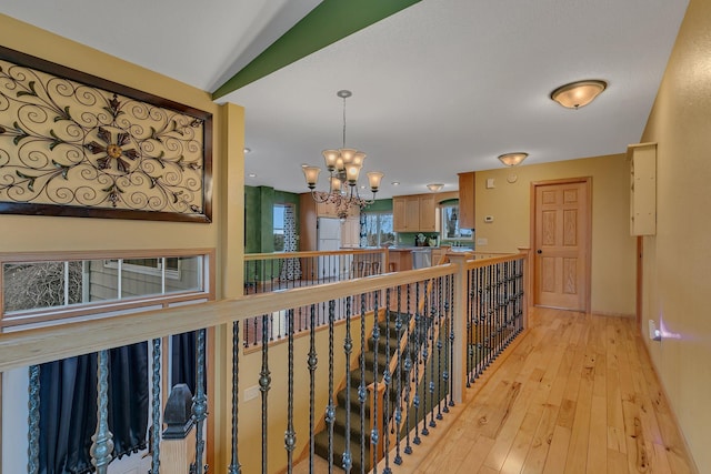 corridor with a chandelier and light wood-style floors