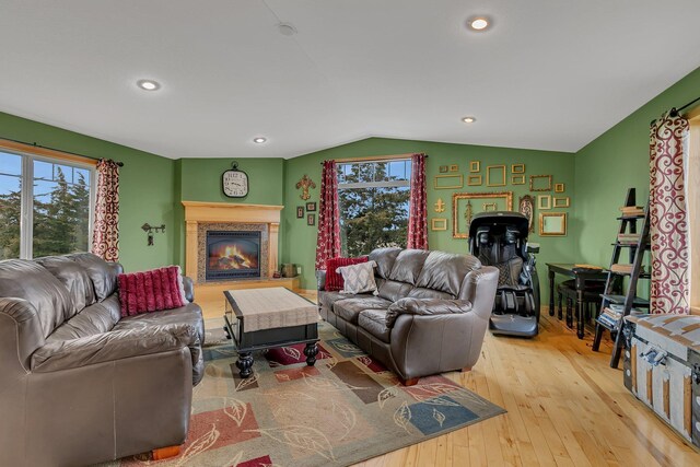 living room with recessed lighting, a healthy amount of sunlight, wood-type flooring, and lofted ceiling