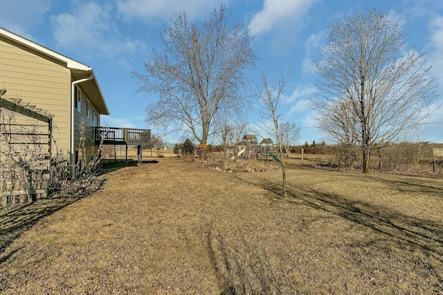 view of yard featuring a wooden deck, a playground, and stairway