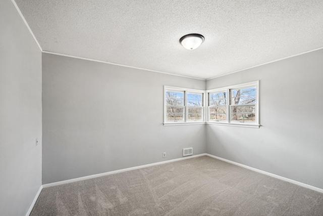 carpeted empty room featuring baseboards, a textured ceiling, and visible vents