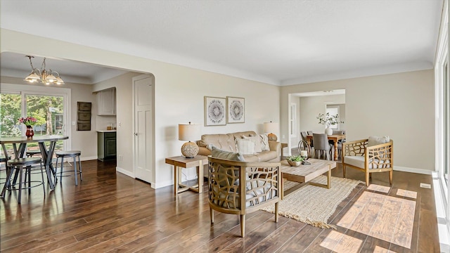 living area with dark wood finished floors, a chandelier, and baseboards