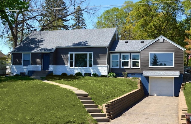 view of front of home featuring an attached garage, concrete driveway, a front yard, and roof with shingles