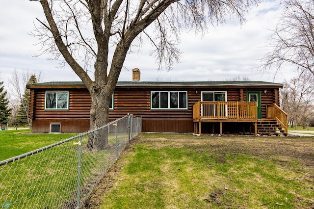 301 3rd Ave S, Borup, MN 56519 - rear view of house featuring a wooden deck, fence, a chimney, log siding, and a lawn