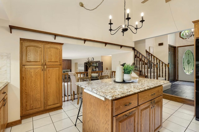 5853 Deer Trail Cir, Woodbury, MN 55129 - kitchen featuring a breakfast bar area, a towering ceiling, a kitchen island, brown cabinetry, and a chandelier