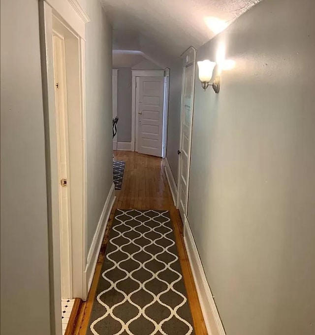 3600 17th Ave S Unit 301, Minneapolis, MN 55407 - corridor featuring lofted ceiling, wood finished floors, and baseboards